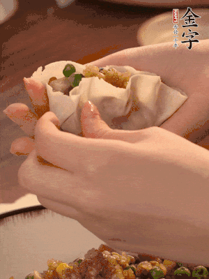 取一大勺餡料放進餃子皮里，用大拇指按住頂部餡料，再用虎口掐出形狀。